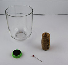 Alle Materialien um dieses Experiment durchzuführen: Glas Korken, Nadel und einen Magneten.